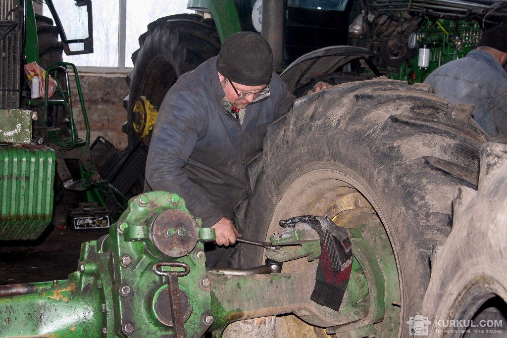 Олександр  Кащук налаштовує розвал-сходження коліс трактора John Deere 8400