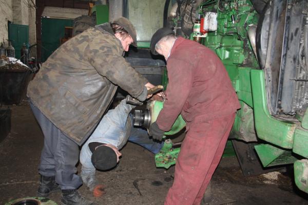 Тракторист Сергій Студенчук допомагає в ремонті бортової